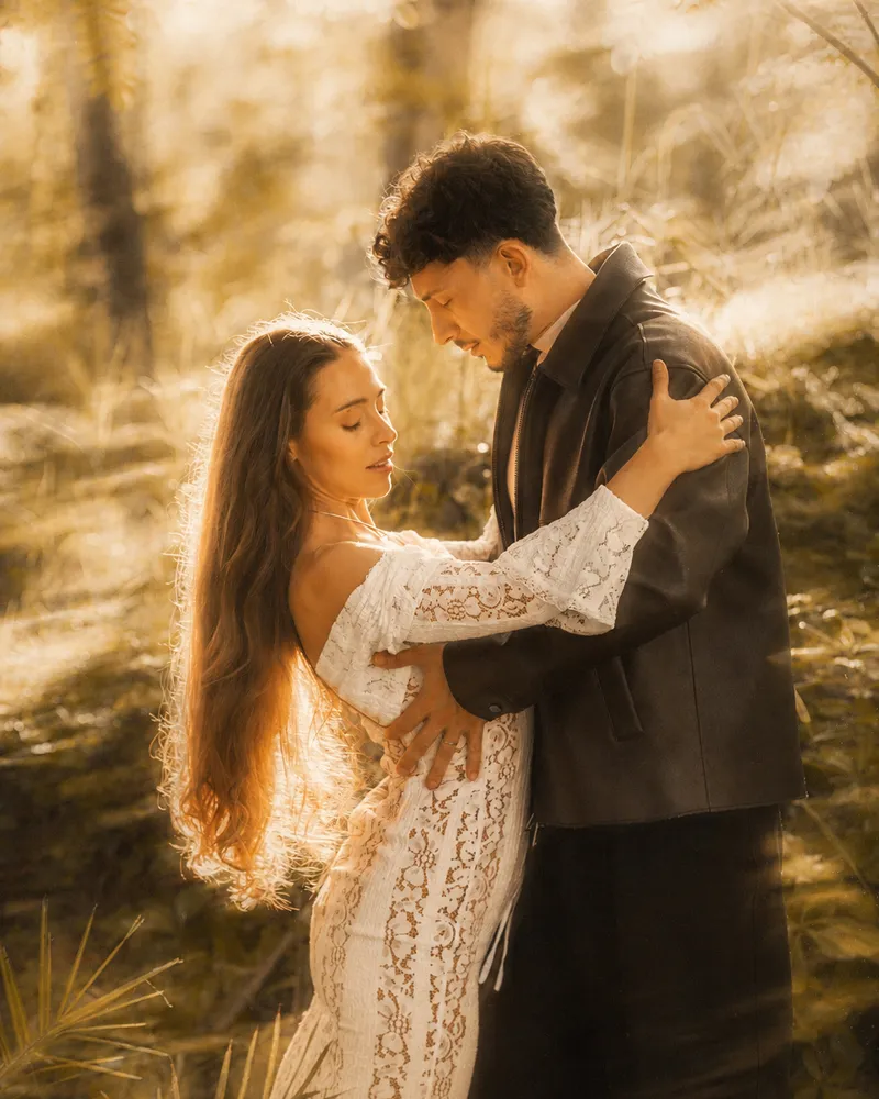 Michael y Mayra close together in a sunlit field