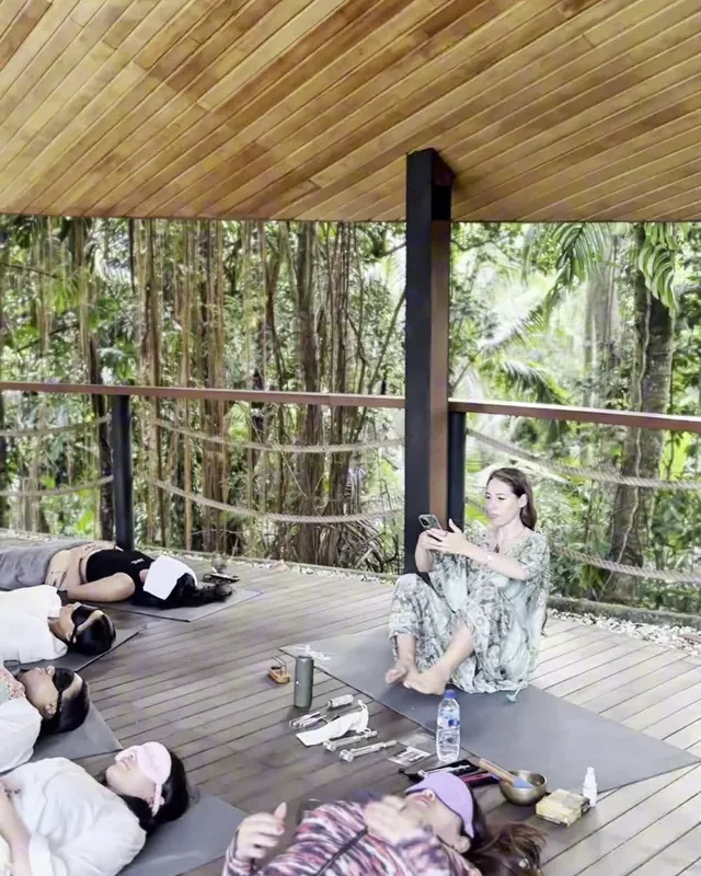 Women lying together in a circle during a practice on the open deck