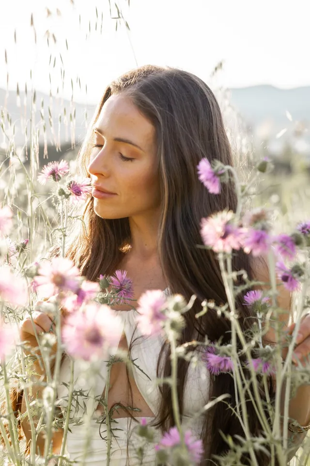 Mayra, eyes closed among wildflowers